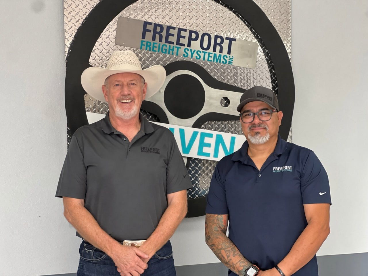 Freeport Freight Systems' owner, left, and second in command standing in front of the company logo at the Sparks office
